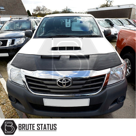 Toyota Hilux 2005-2016 PU Coated Bonnet Bra on a parked black and white truck, showcasing protection and durability against road debris and harsh weather.