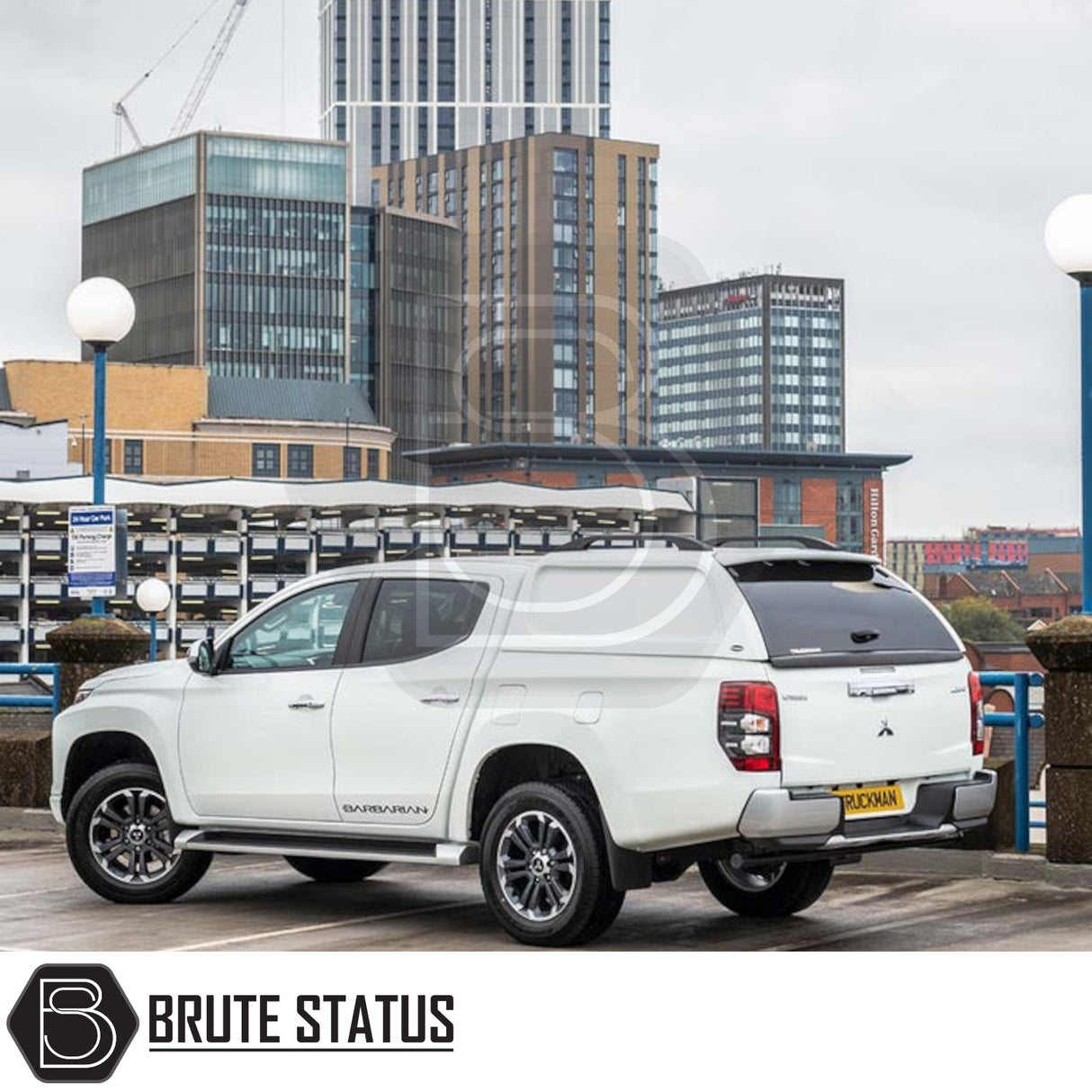 Mitsubishi L200 with Truckman L-Series Hardtop Canopy, featuring remote locking and enhanced storage, parked in a cityscape, showcasing Brute Status's pickup accessories.