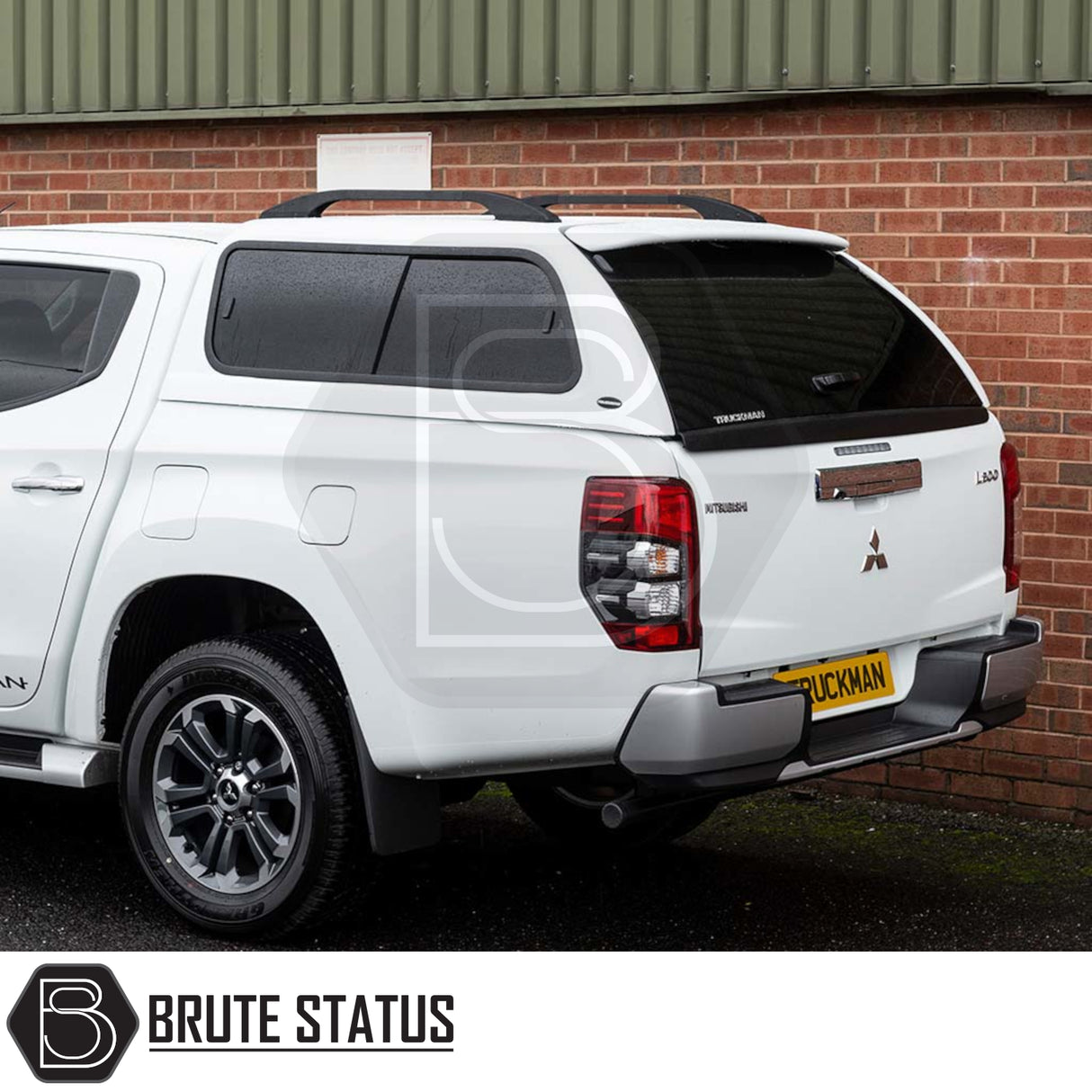 Mitsubishi L200 with Truckman GLS canopy, featuring tinted windows, alloy wheels, and remote locking, set against a brick wall.