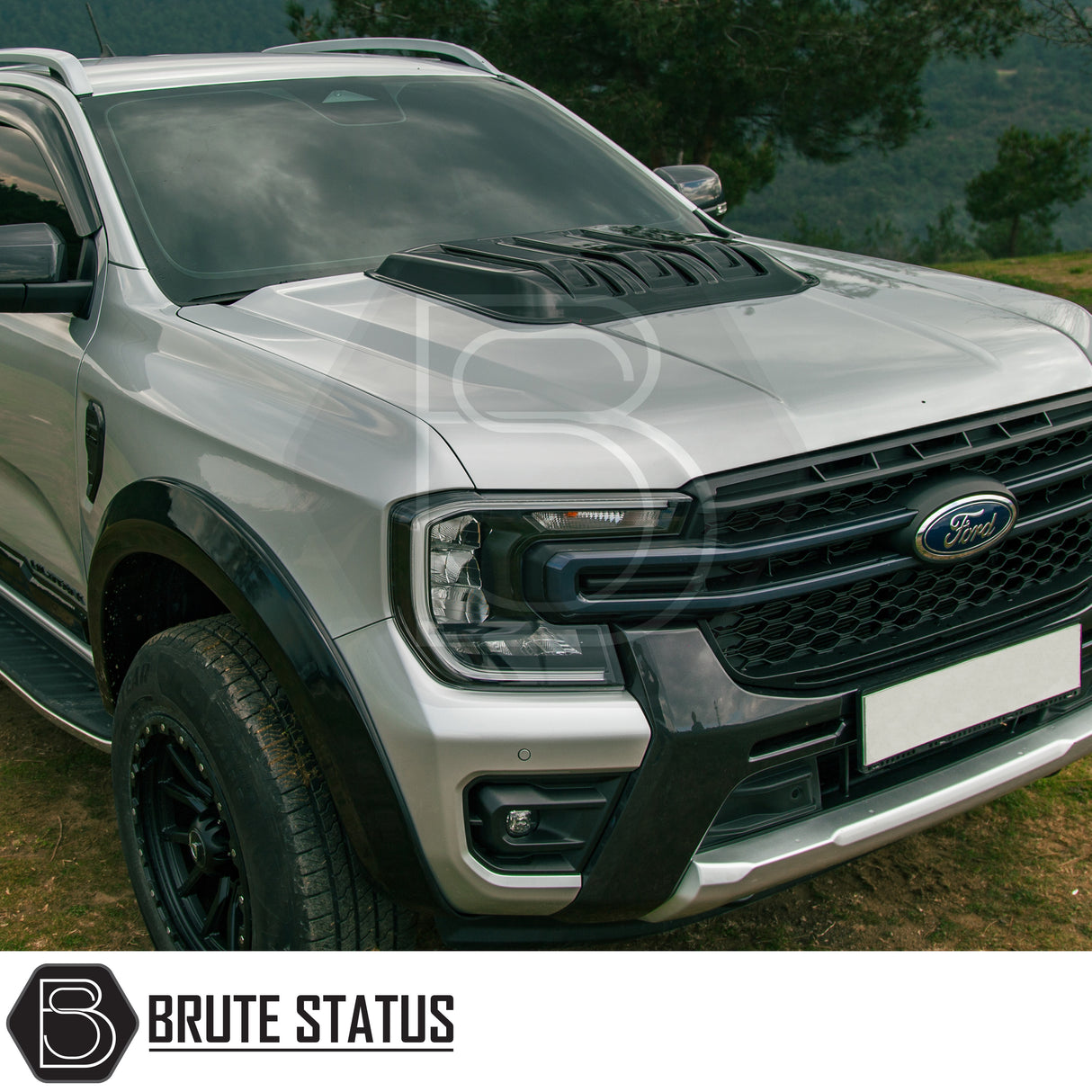 Ford Ranger T9 2023+ Raptor Style Bonnet Scoop Vent in gloss black, featuring a bold hood scoop and off-road enhancements, parked amid a natural backdrop.