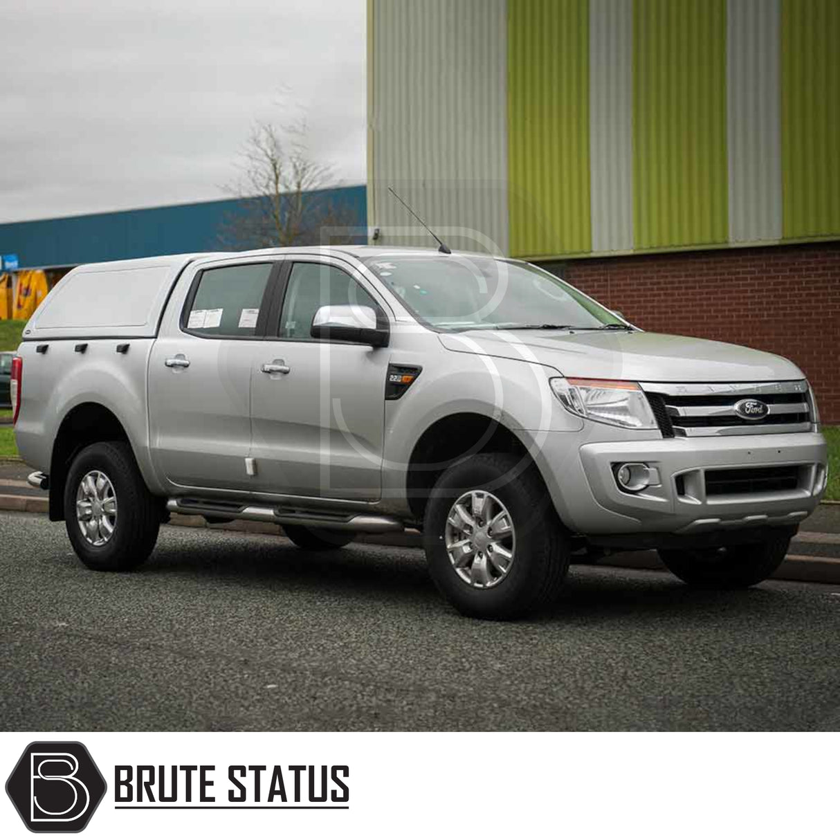 Silver Ford Ranger with Truckman RS Hardtop Canopy, solid rear window, parked before industrial building, showcasing enhanced security and durability for commercial use.
