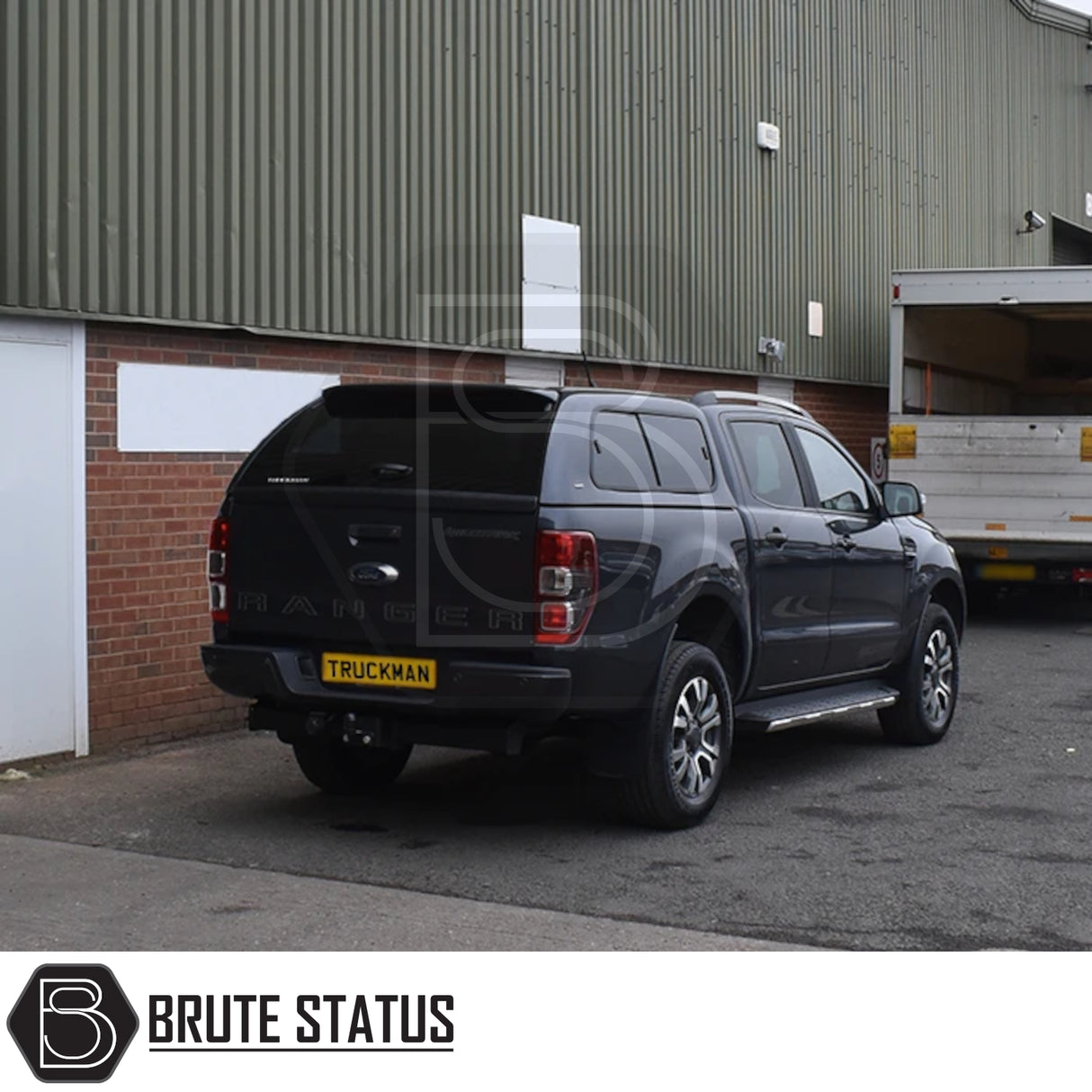Ford Ranger 2012-2022 hardtop canopy with lockable, tinted sliding windows, parked by an industrial warehouse, showcasing Brute Status’s sporty, secure truck accessory.