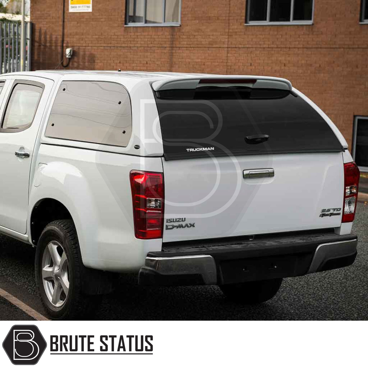 Isuzu D-Max 2012-2021 Truckman Grand Hardtop Canopy with tinted windows and remote locking, enhancing the truck's functionality and style against a brick building backdrop.