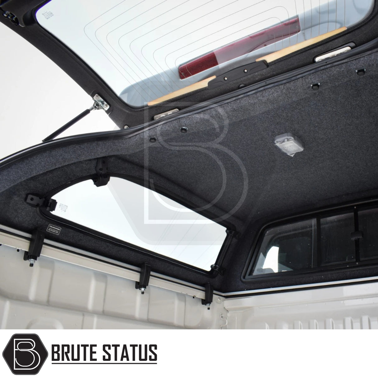 Interior of Isuzu D-Max 2025+ Truckman Grand Hardtop Canopy with remote locking, featuring pop-out windows, dome light, and branded Brute Status watermark.