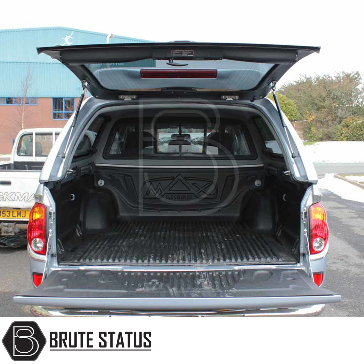 Mitsubishi L200 Series 4 Truckman Grand canopy with open hatch, showcasing spacious, carpet-lined bed; features remote locking, pop-out windows.