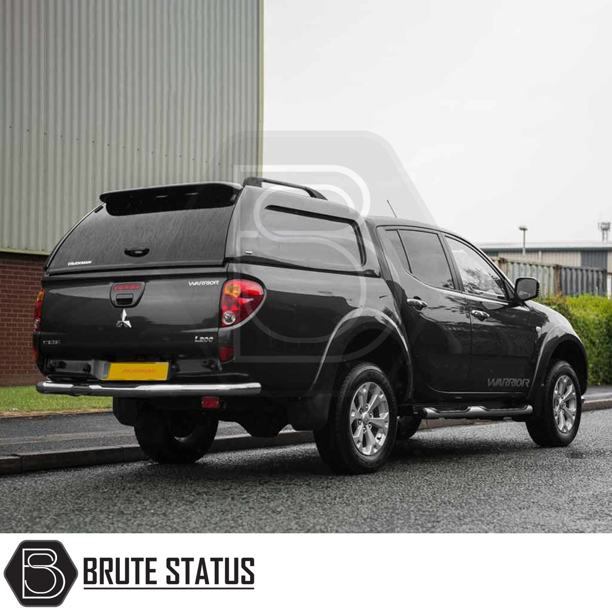 Mitsubishi L200 2010-2015 Series 4 Truckman L-Series Hardtop Canopy with remote locking, parked on wet street, enhancing pickup's security and storage capacity.