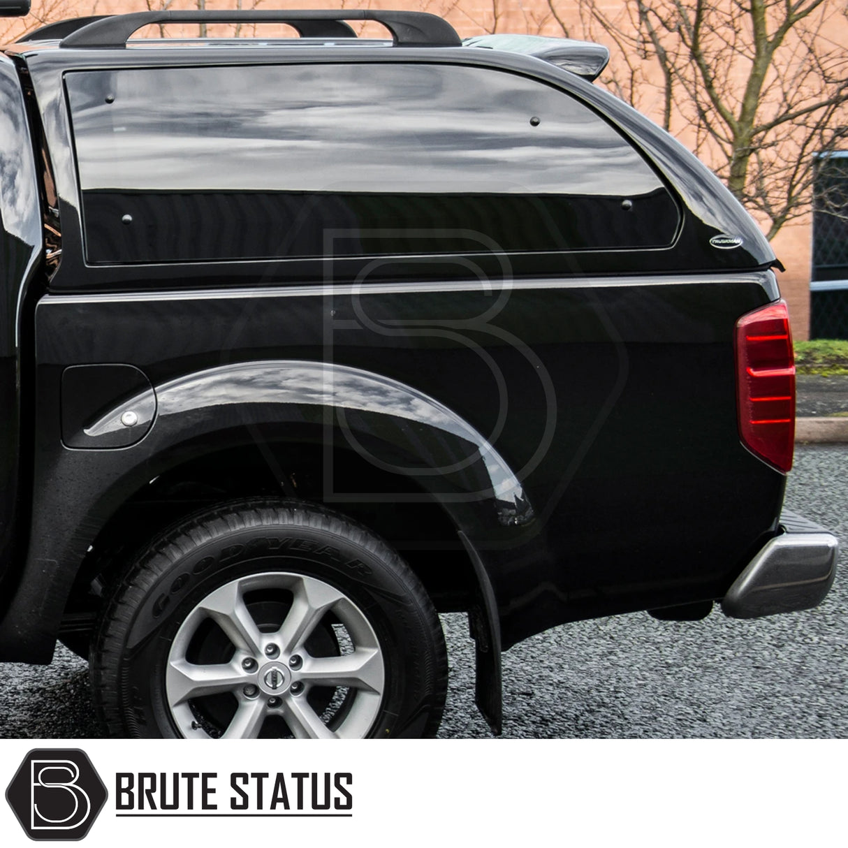 Nissan Navara 2005-2015 D40 Truckman Grand Hardtop Canopy with rear view showing tinted windows and Brute Status logo, showcasing secure and stylish storage.