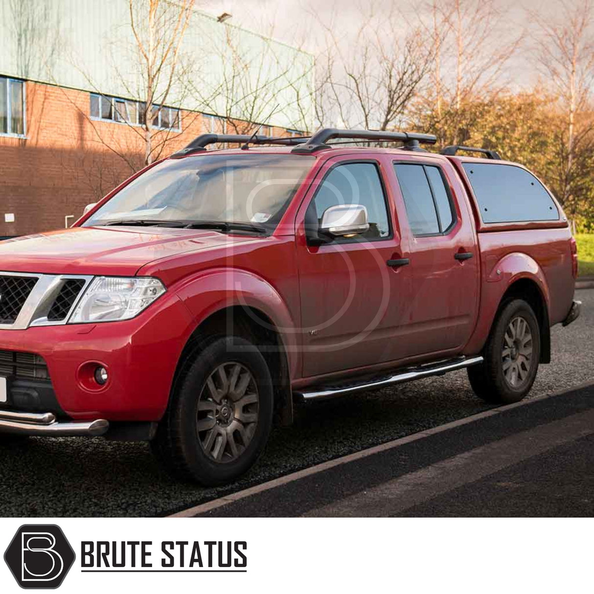 Nissan Navara 2005-2015 D40 Truckman Grand Hardtop Canopy with remote locking and roof racks, parked by a brick building.