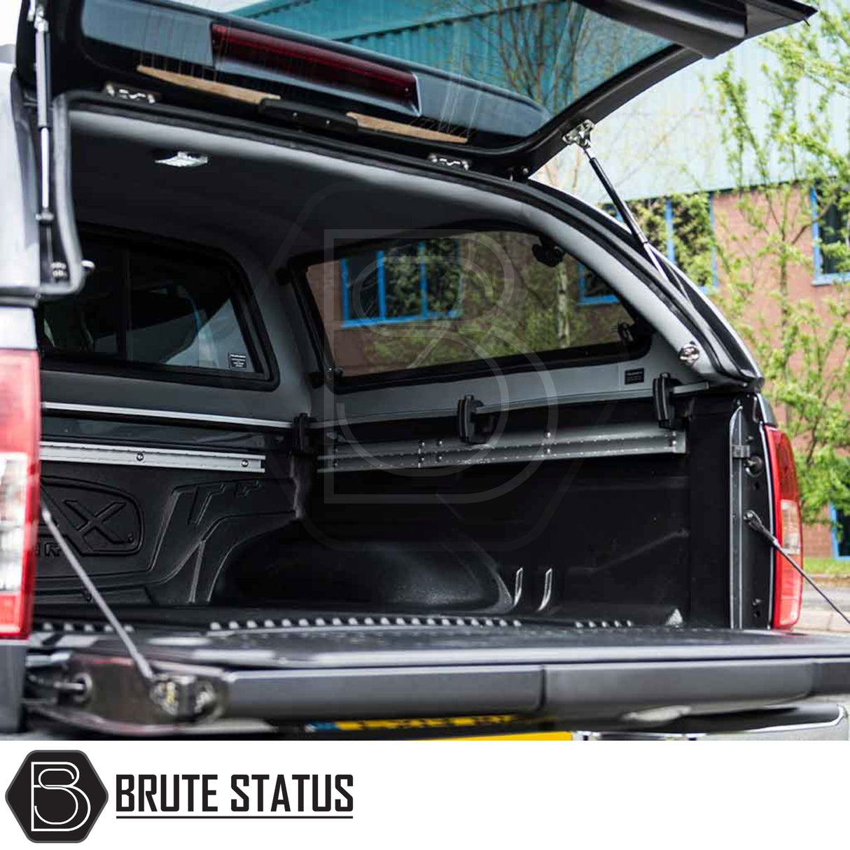 Nissan Navara 2005-2015 D40 Truckman Grand Hardtop Canopy with open hatch and empty bed liner, showcasing remote locking and aerodynamic design features.