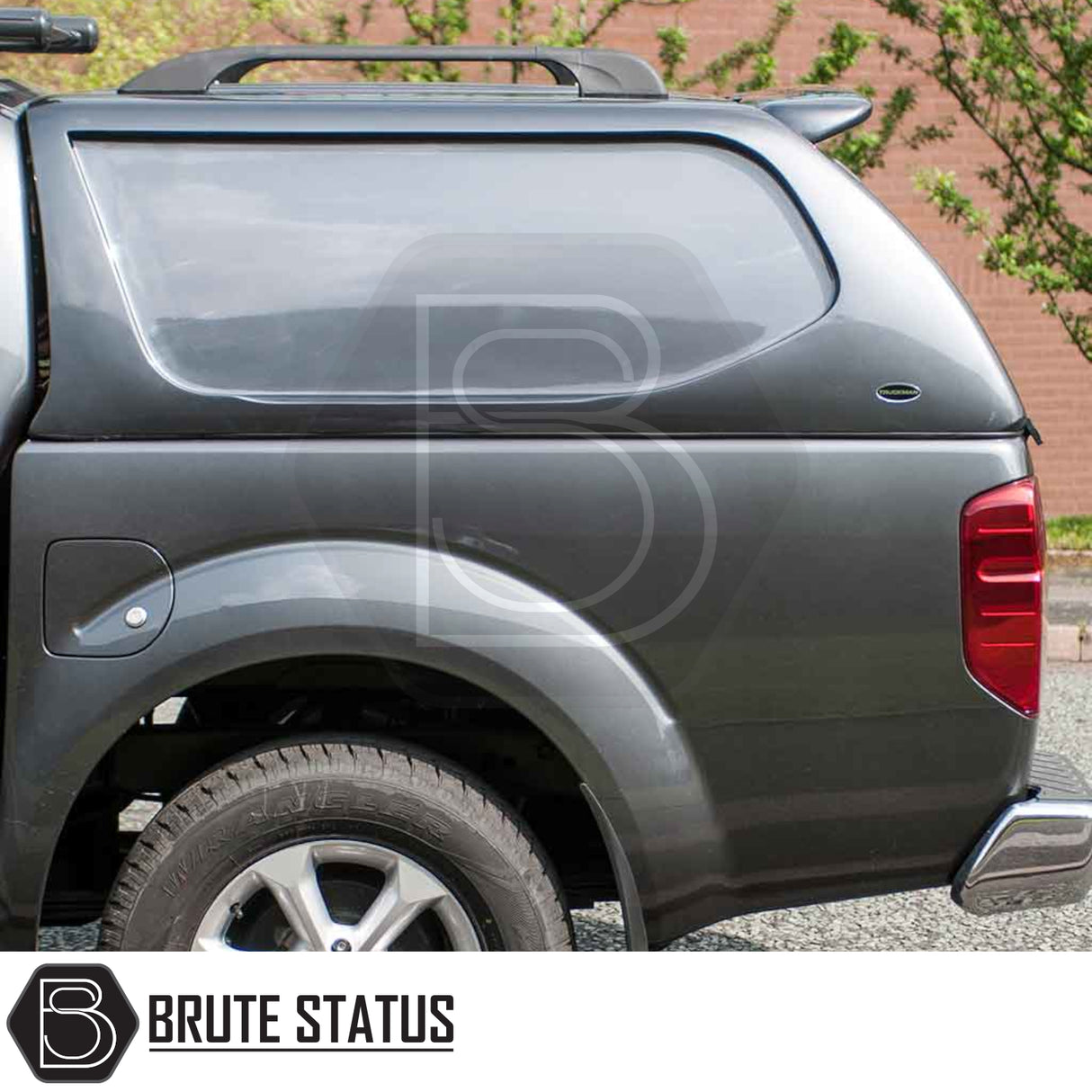 Rear view of dark gray Nissan Navara 2005-2015 D40 with Truckman L-Series Hardtop Canopy, showcasing secure, remote-locking, solid-sided design for enhanced cargo protection.