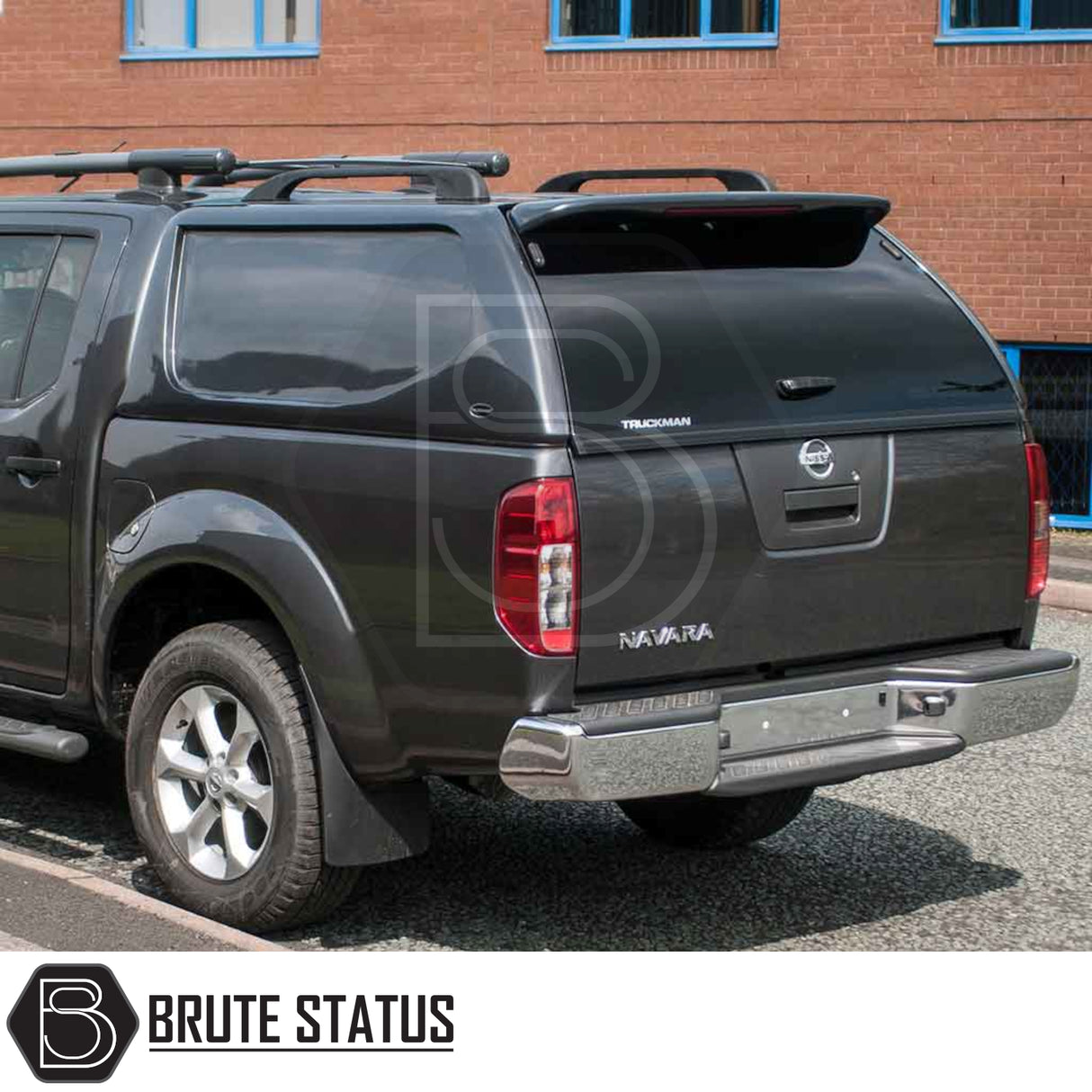 Nissan Navara 2005-2015 D40 Truckman L-Series Hardtop Canopy with remote locking, enhancing storage and security, fitted on a black pickup parked by a brick building.