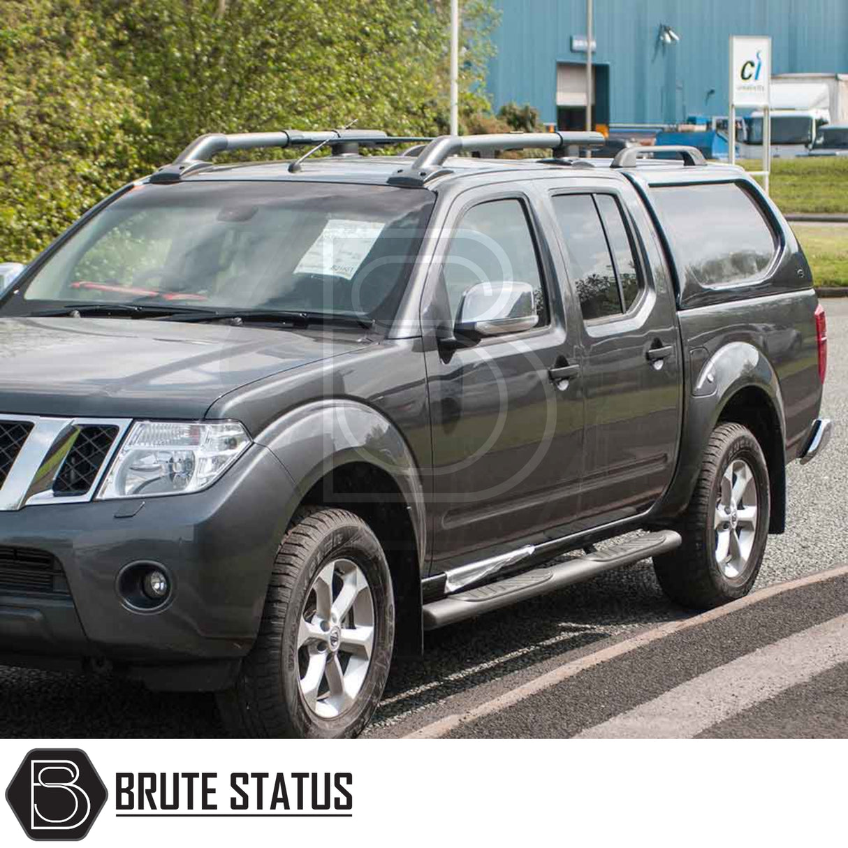 Nissan Navara 2005-2015 D40 Truckman L-Series Hardtop Canopy with remote locking, enhancing security and storage, parked in front of an industrial building.