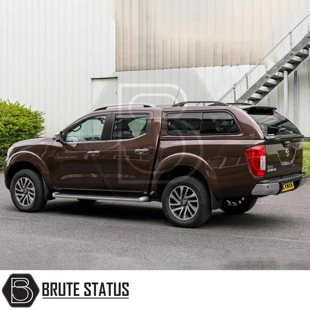 Nissan Navara 2015-2023 NP300 with Truckman GLS Hardtop Canopy featuring lockable sliding windows and remote locking, parked outside a corrugated-metal building.
