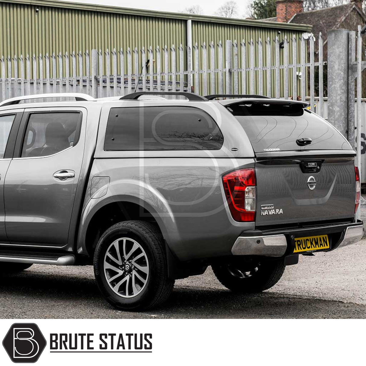 Nissan Navara 2015-2023 NP300 Truckman Grand Hardtop Canopy with remote locking, featuring a stylish design and tinted windows, parked by a metal fence.