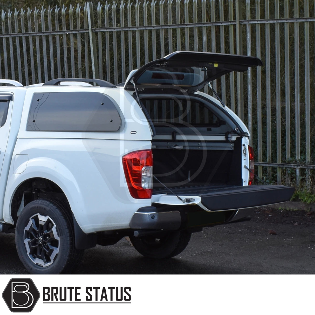 Nissan Navara 2015-2023 NP300 Truckman Grand Hardtop Canopy with remote locking, open tailgate showing empty cargo bed, canopy branded with Brute Status.
