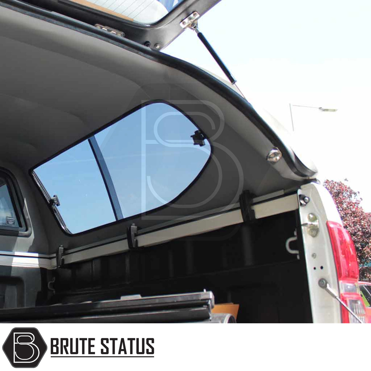 Toyota Hilux 2005-2016 Truckman GLS hardtop canopy with open rear hatch, revealing truck bed, tinted side window, and visible Brute Status branding.