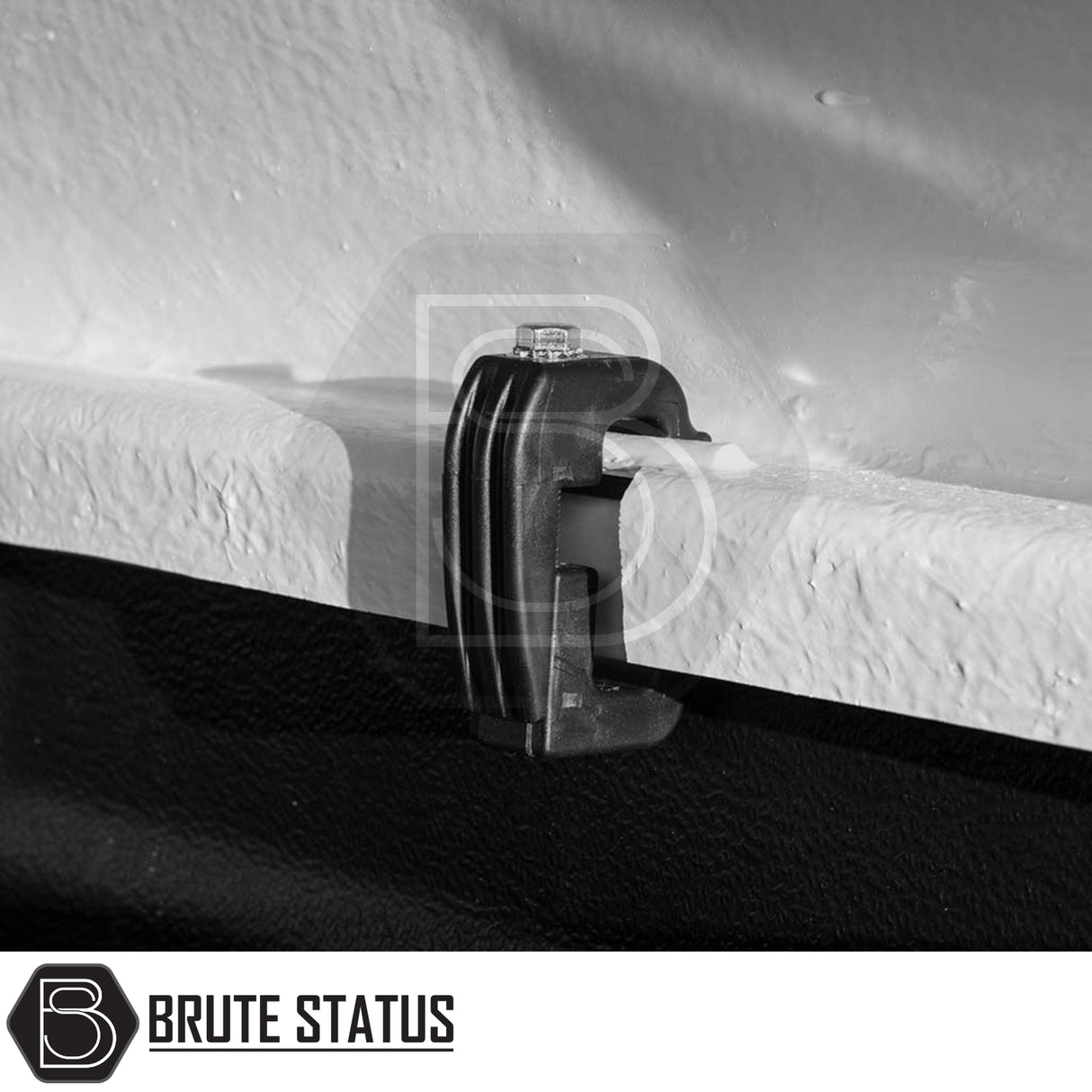 Close-up of a black clamp from Brute Status, securing a panel, used with the Toyota Hilux 2016+ Truckman RS Hardtop Canopy for secure accessory mounting.