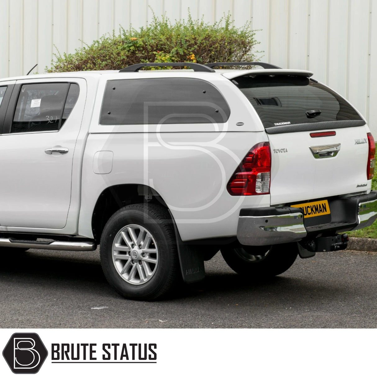 Rear view of Toyota Hilux with Truckman Grand Hardtop Canopy, featuring tinted side windows, roof rails, and chrome bumper, enhancing storage and security.