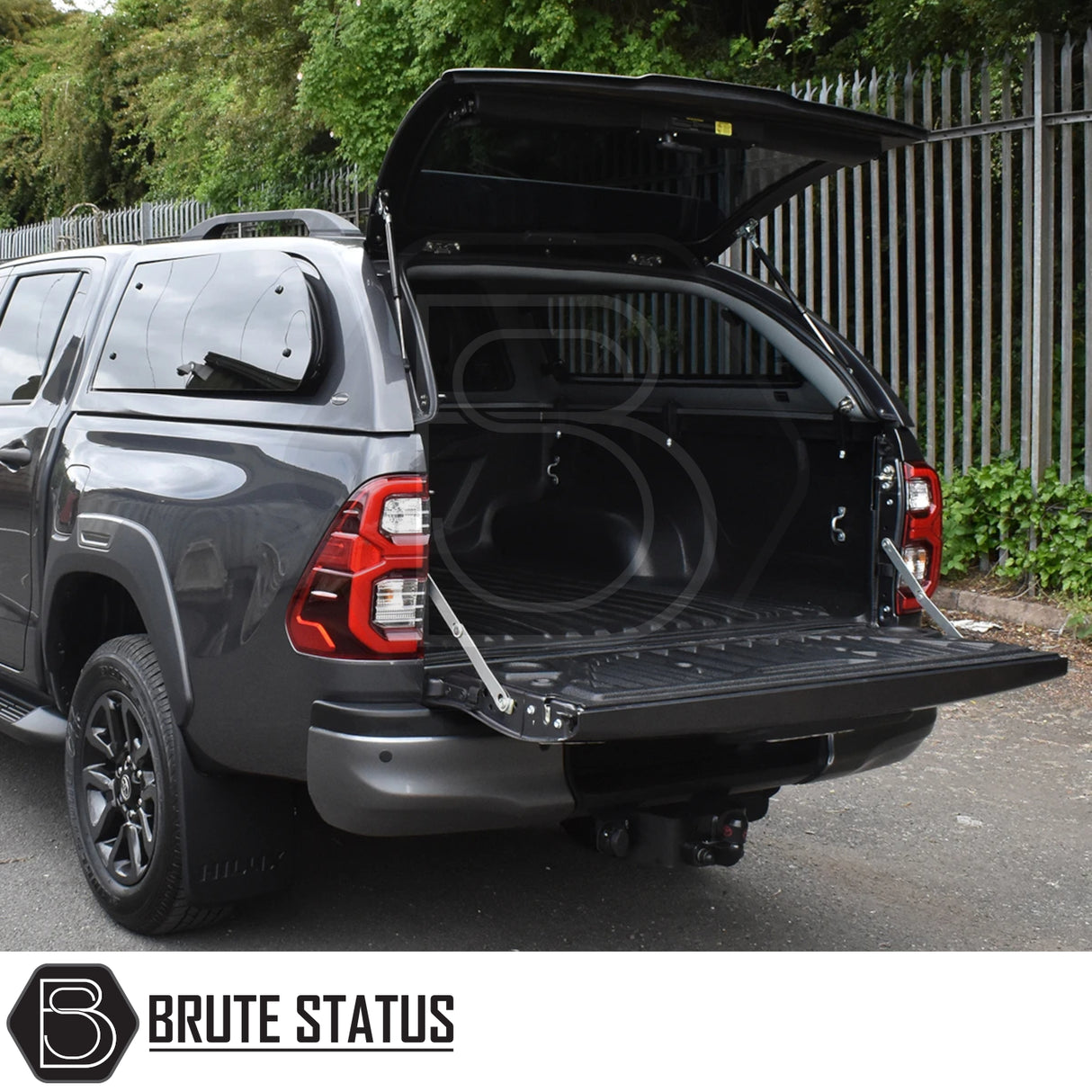 Toyota Hilux Invincible X with a Truckman Grand Hardtop Canopy, featuring a lockable canopy and open tailgate, revealing an empty, plastic-lined bed.