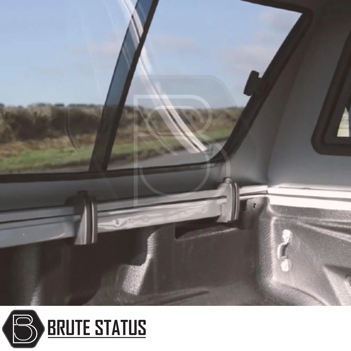 View from a pickup's bed showing a Volkswagen Amarok 2010-2022 Truckman GLS Hardtop Canopy with sliding rear window and aftermarket tonneau-cover rail.