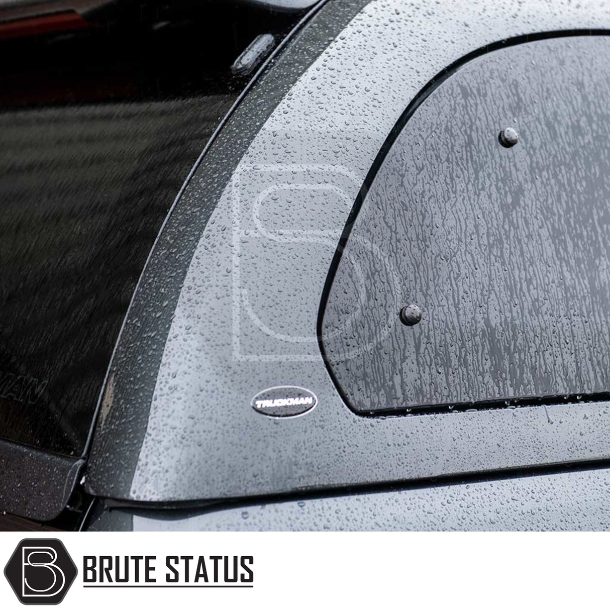 Close-up of Volkswagen Amarok 2010-2022 Truckman Grand Hardtop Canopy with water beading, TRUCKMAN badge, and remote locking feature on rear panel.