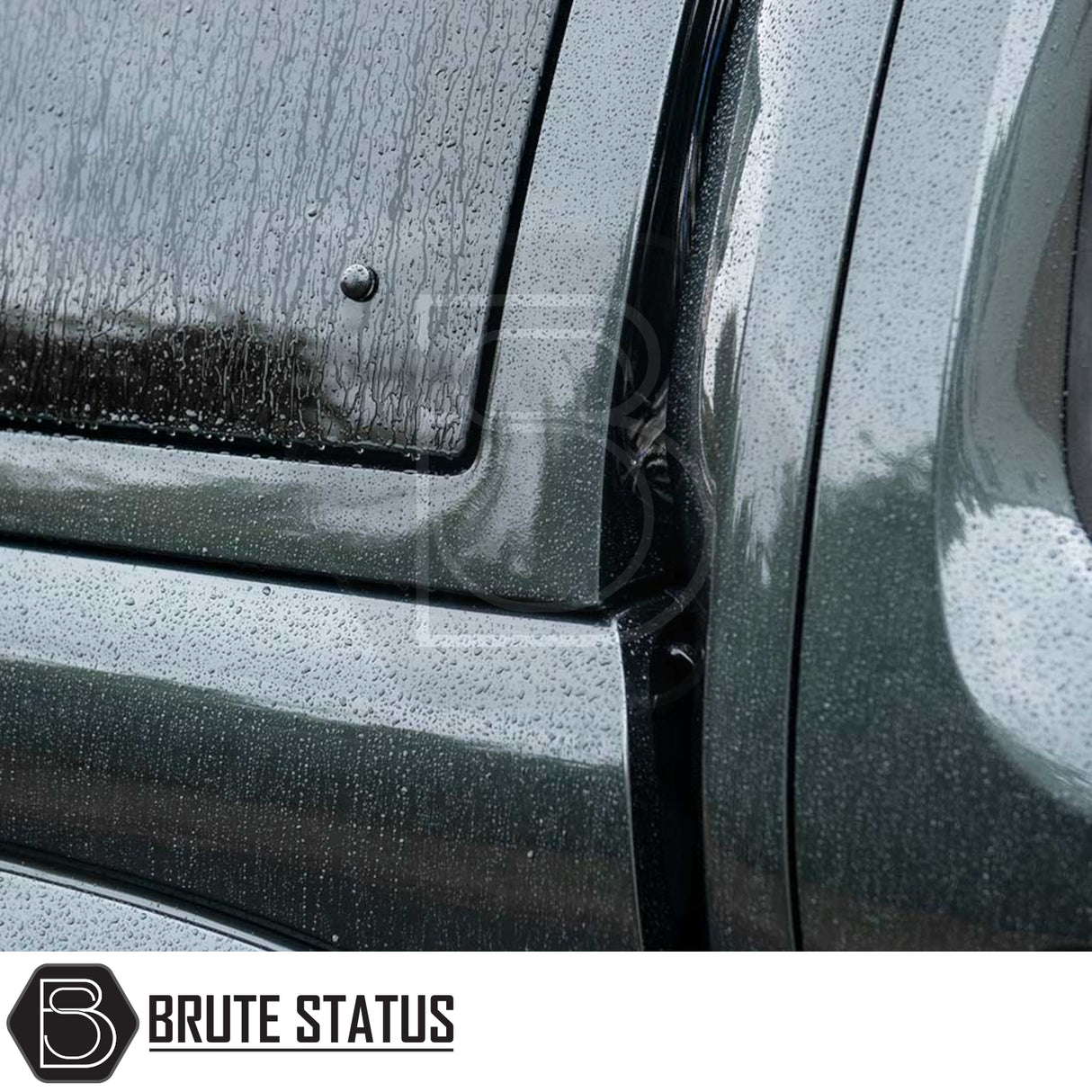 Close-up of Volkswagen Amarok 2010-2022 Truckman Grand Hardtop Canopy with Brute Status logo, showcasing raindrop-covered edge meeting the truck’s bed and cab.