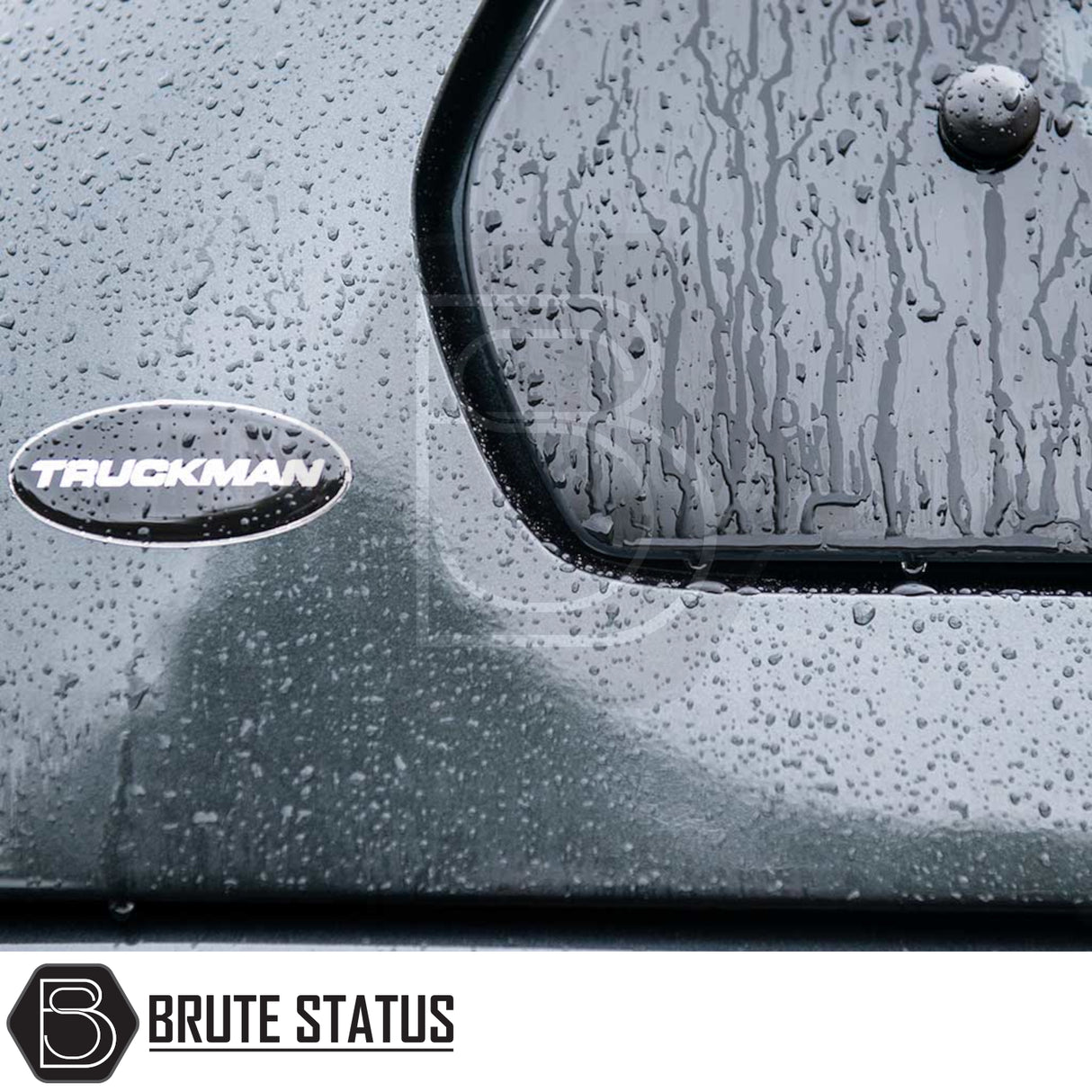 Close-up of rain-spattered Volkswagen Amarok Truckman Grand Hardtop Canopy, featuring TRUCKMAN badge and BRUTE STATUS logo, highlighting premium design and remote locking.
