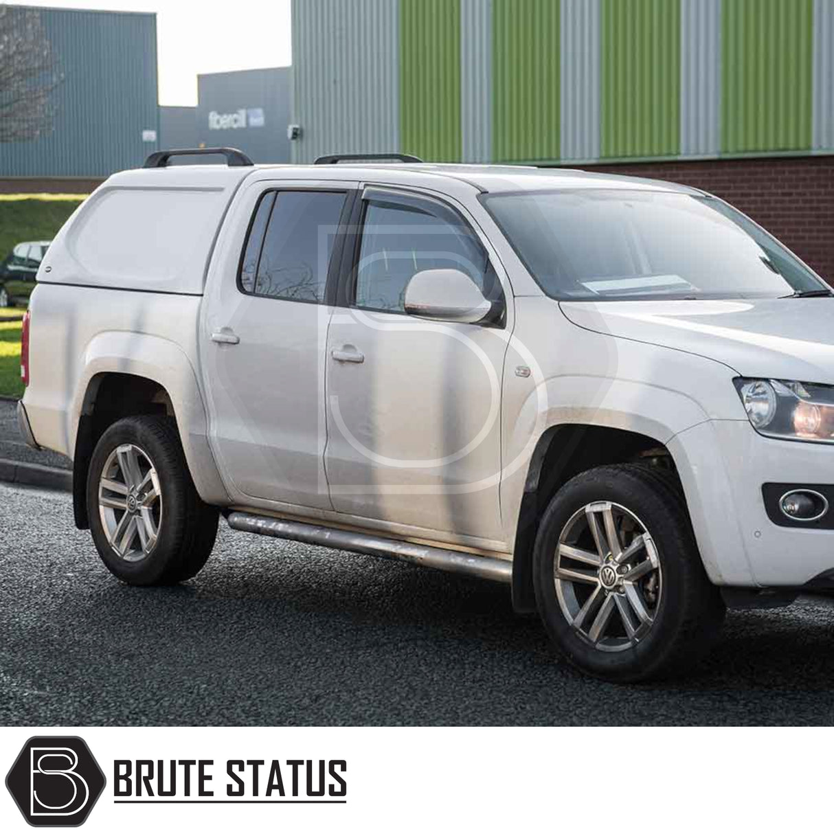 Volkswagen Amarok with Truckman L-Series Hardtop Canopy, featuring solid sides and alloy wheels, parked in front of an industrial building.