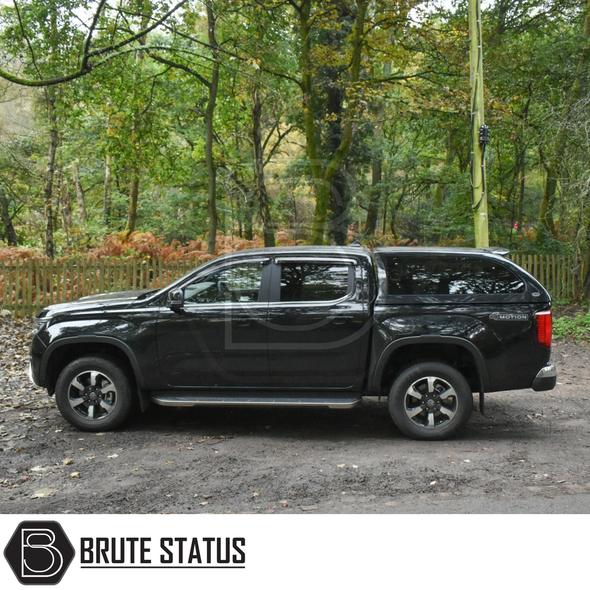 Volkswagen Amarok 2023+ Truckman Grand Hardtop Canopy with remote locking, showcased in a wooded area, featuring tinted pop-out windows and a sleek design.