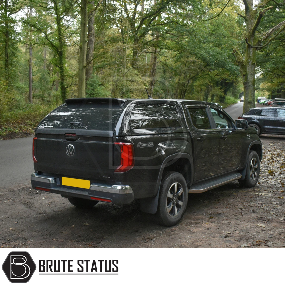 Volkswagen Amarok 2023+ Truckman Grand Hardtop Canopy - Remote Locking, featuring cab-high design, tinted pop-out windows, and a luxurious carpet-lined interior beside a forest road.
