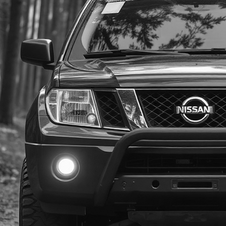 Black and white image of a Nissan Navara D20 front, highlighting its grille and headlights, reflecting Brute Status's focus on vehicle customization and enhancement.