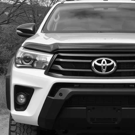 Close-up of a sport utility vehicle's front, showcasing the grille and bumper, associated with Brute Status' custom aftermarket enhancements for a distinctive style.