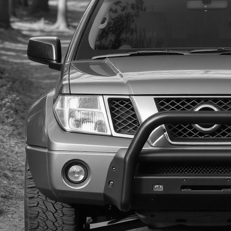 Black and white image of the front of a Nissan SUV, showcasing aftermarket enhancements like custom grille and bumper, reflecting Brute Status's vehicle customization focus.