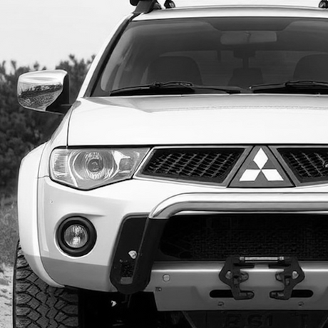 Close-up of a parked SUV with visible roof rack and grille, showcasing potential for customization with aftermarket accessories.