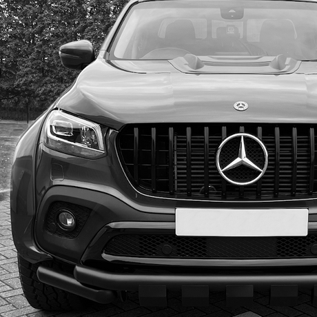 Front view of a luxury SUV featuring a prominent grille and bumper, highlighting aftermarket design enhancements typical of Brute Status's customization offerings.