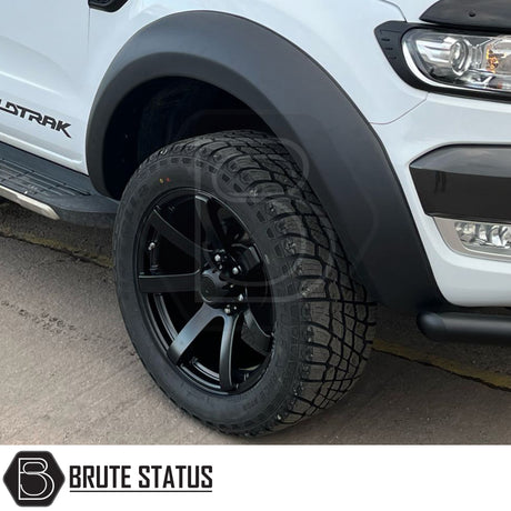 AXE Wheels Quake in Matt Black, showcasing a close-up of the alloy wheel rim with a distinctive red logo, highlighting its design and craftsmanship.