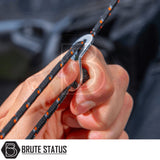 Person feeds climbing rope through figure-8 descender, branded Brute Status, showcasing ARB Esperance 2.0 Rooftop Tent Annex Room for enhanced camping comfort.