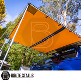 ARB Awning Alcove attached to a blue pickup, providing shaded canopy over camp setup, showcasing Brute Status's accessory for enhanced outdoor comfort and convenience.