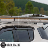 White SUV by lake with ARB Awning Alcove on roof bars, showcasing a rolled-up awning for versatile outdoor protection. Forested shoreline in the background.