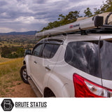 White SUV with ARB Aluminium Case Awning & LED Light Kit on roof, parked on grassy hill. Features chunky tires, side steps, tinted windows; ideal for off-road adventure.