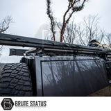 ARB Aluminium Case Black Awning & LED Light Kit 2m x 2.5m on Brute Status roof rack with spare tire and stowed gear, ideal for versatile overland adventures.