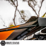 Close-up of ARB Awning Alcove on vehicle roof, showcasing ARB hardware and support arms with orange canopy, enhancing outdoor comfort and protection. Brute Status logo visible.