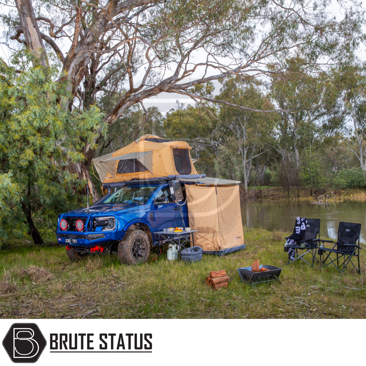 Overland campsite with ARB Ensuite Room & Instant Shower Tent on a 4×4 pickup, featuring a fold-out rooftop tent, off-road accessories, and camping gear by a river.