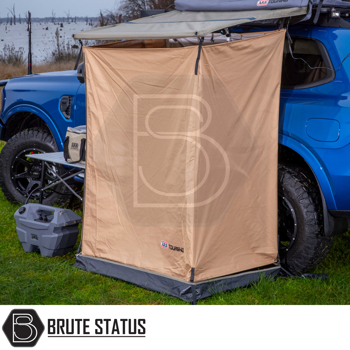 ARB Ensuite Room & Instant Shower Tent on blue 4x4, featuring Brute Status annex, ARB shower unit, camp table with cooler, ideal for private outdoor showering.