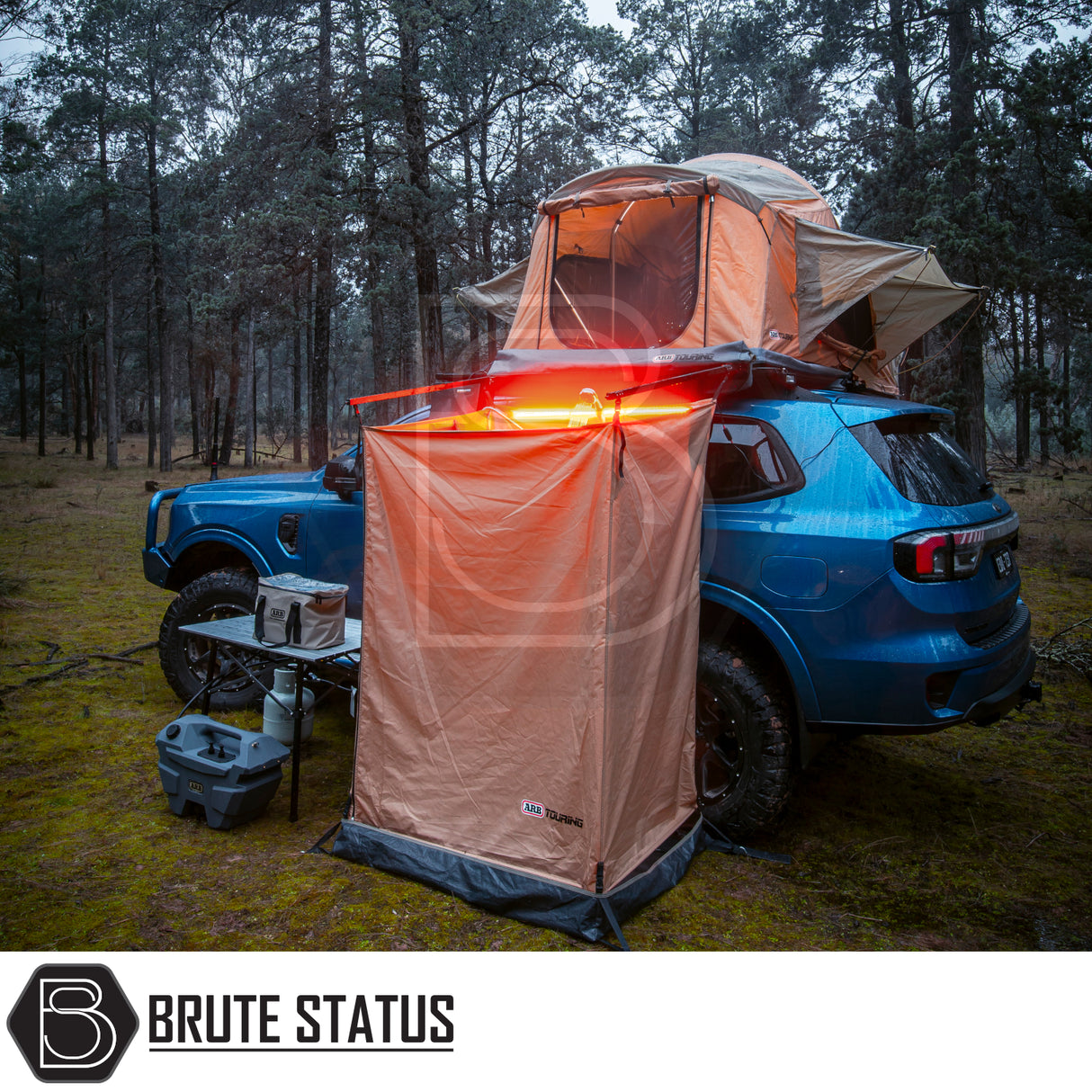 ARB Simpson III Rooftop Tent & Annex on a blue 4x4 SUV with privacy shelter, camp kitchen, and ARB fridge/freezer, showcasing overland camping setup.