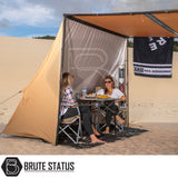 Lightweight ARB PVC Case Awning & LED Light Kit 2.5m x 2.5m pitched on sand, with two women seated underneath, showcasing camping setup and accessories.