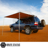 ARB Awning 2m x 2.5m on a 4x4 SUV in desert, creating shaded area with telescopic poles. Ideal for outdoor adventures. Includes Brute Status logo.