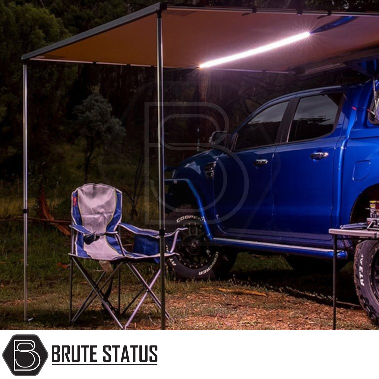 Blue 4x4 pickup with ARB Awning Alcove and integrated LED light, creating a sheltered space with camp chair and table, ideal for versatile outdoor protection.
