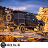 Matte-black 4x4 expedition vehicle with ARB Aluminium Case Silver or Black Awning & LED Light Kit, parked on rocky outcrop, showcasing off-road accessories.