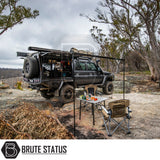 Off-road setup featuring ARB Aluminium Case Awning with LED Light Kit on a four-wheel-drive, showcasing camping gear under bushland setting.